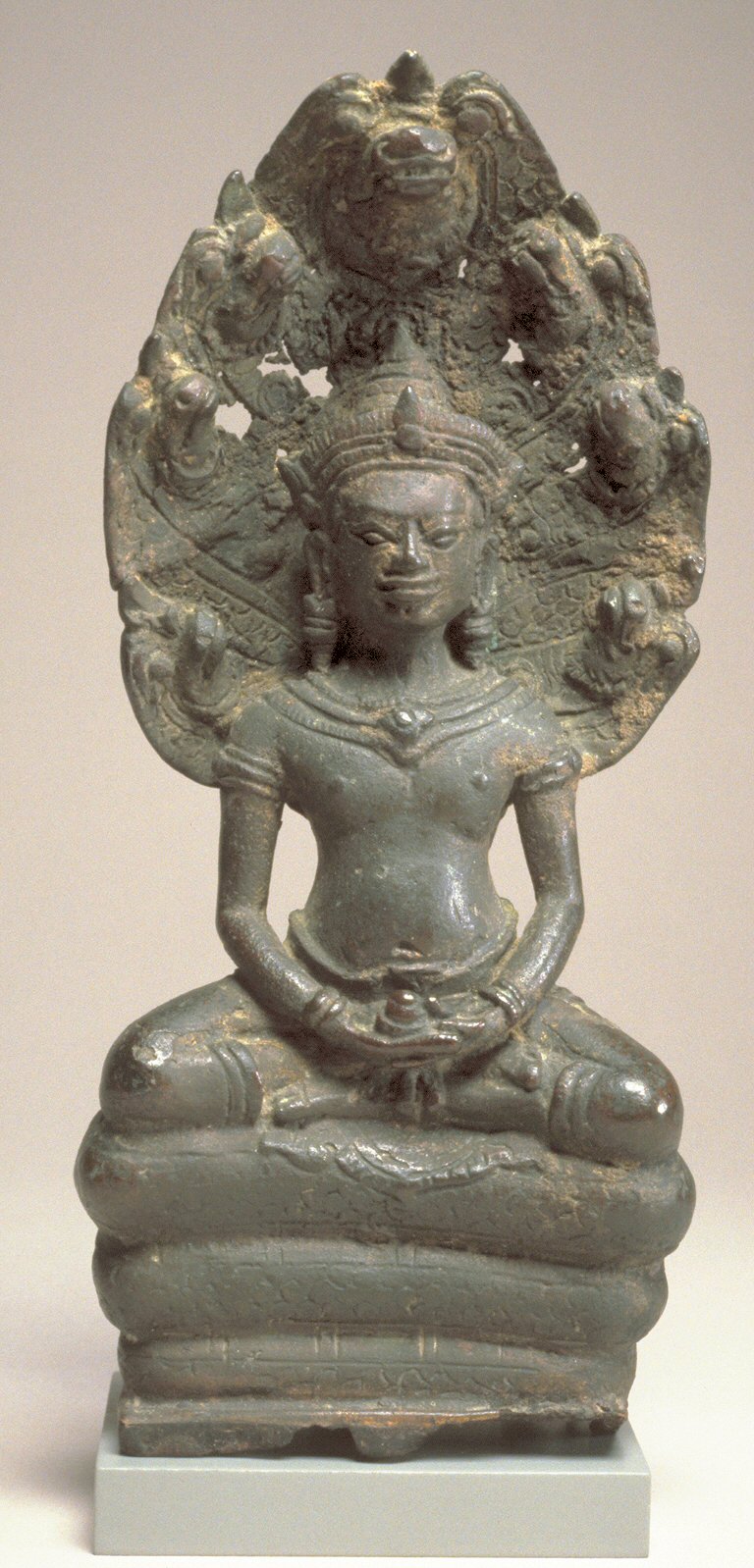 Khmer bronze amulet (Angkorian and post-Angkorian figurines) — This bronze Buddha holds an object in his hands, a container or a gem- possibly but not certainly an attribute of the he