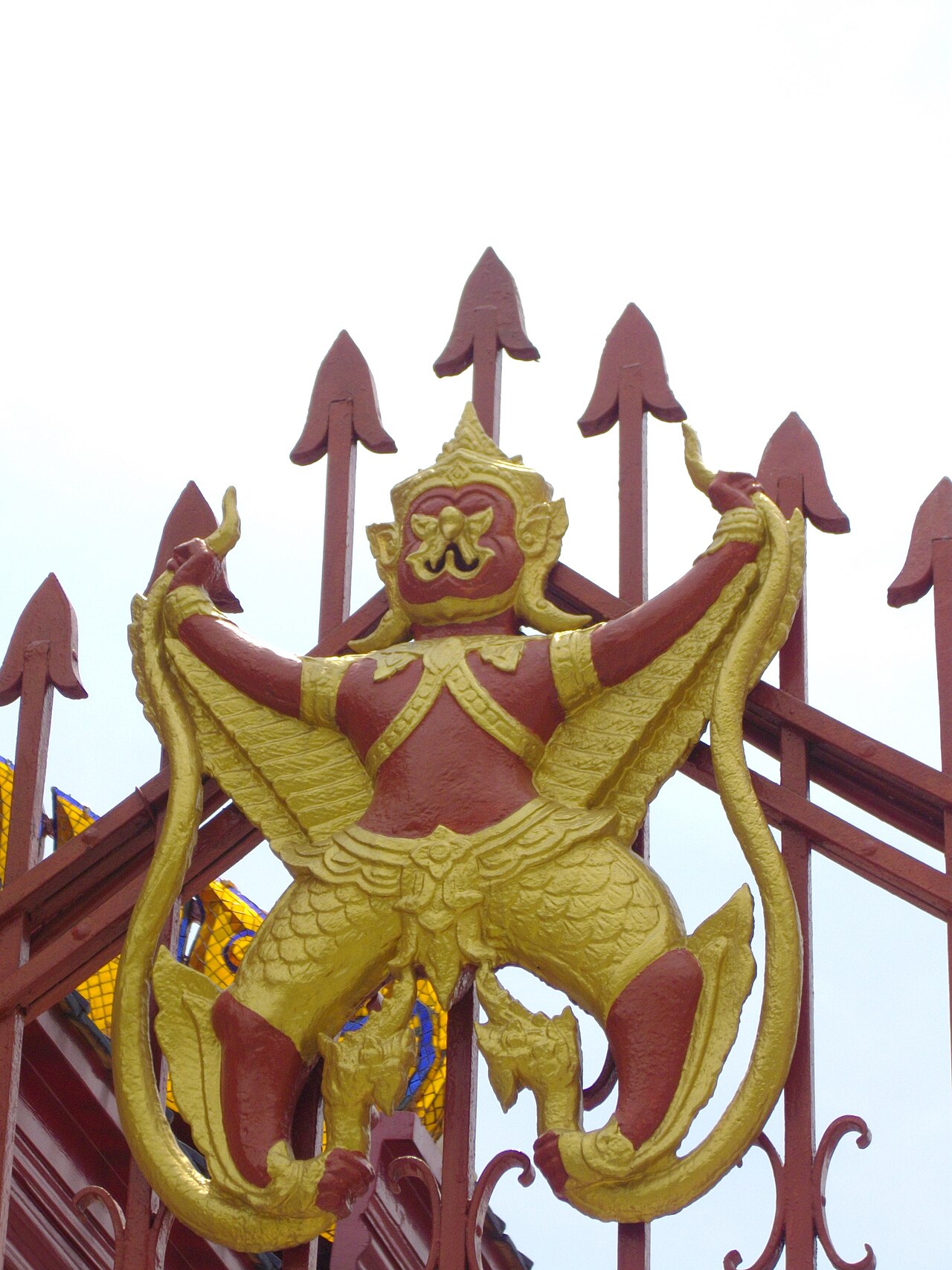 Phaya Khrut (the garuda) — ตราพระราชลัญจกรประจำพระองค์พระบาทสมเด็จพระพุทธเลิศหล้านภาลัย (พระราชลัญจกรครุฑยุดนาค) ประดับรั้วเหล็กรอบบริเวณพระปรางค์ว