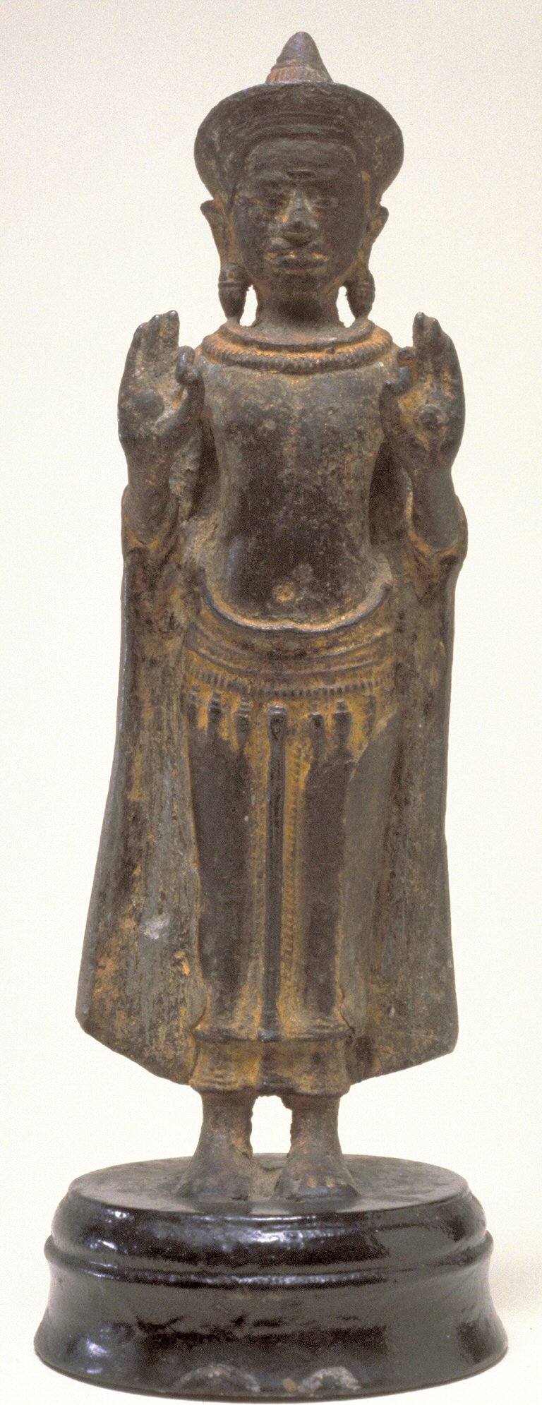 Khmer bronze amulet (Angkorian and post-Angkorian figurines) — This bronze may be one of the older images of the standing crowned Buddha; among the features that may be considered eal