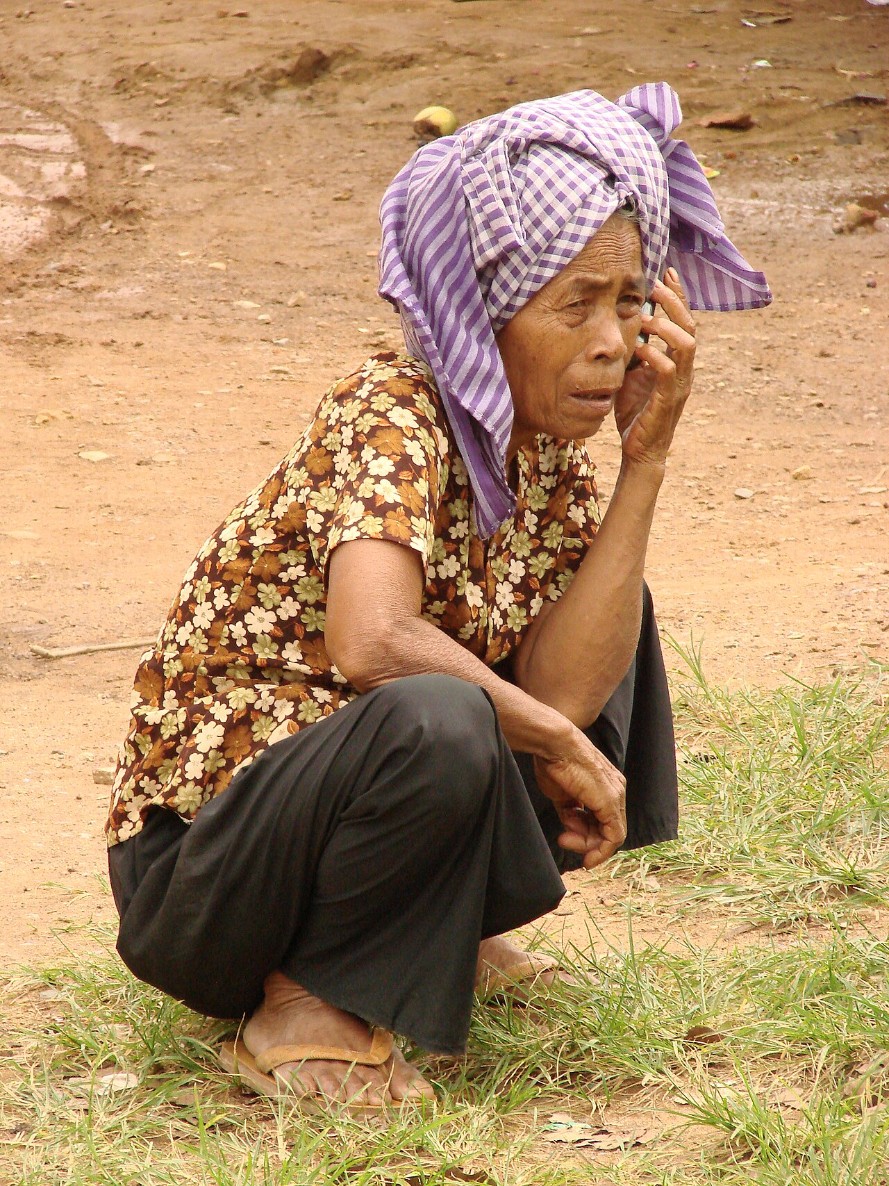 Khmer yantra cloth — A market woman talks on her cell phone in Kep, Cambodia. May 2009.