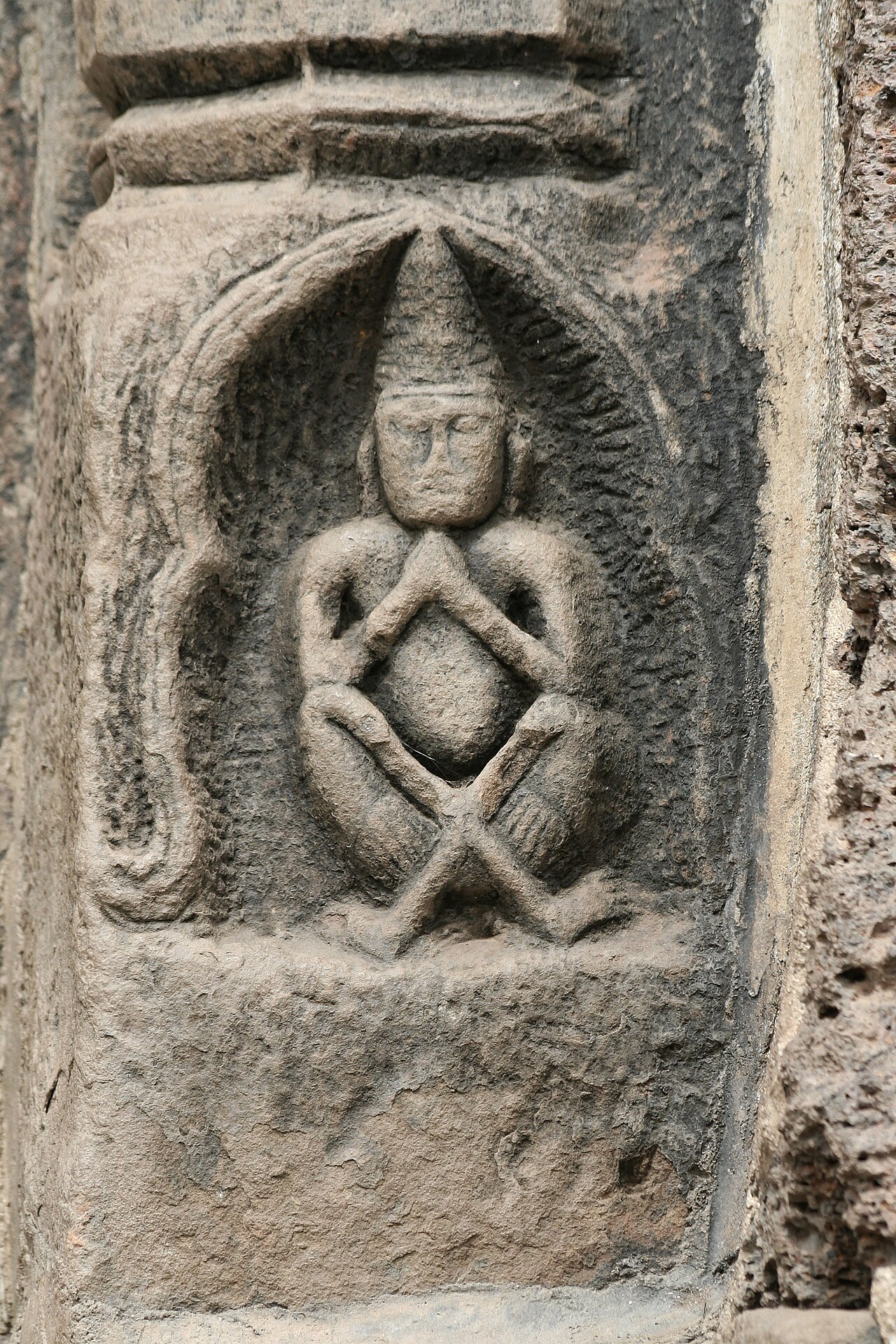 Phra Lersi figure (the hermit-teacher) — Carving of Rishi (Hermit) in the base of a colonette of the southern door of Prang Sam Yod, Lopburi, Thailand.