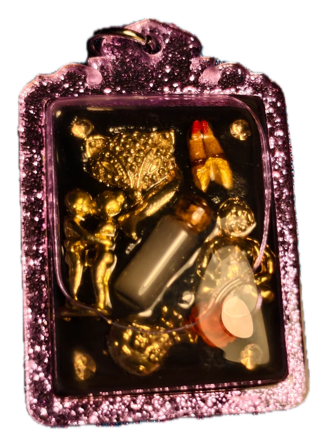 เครื่องรางสายพนัน หล่อเรซิน กรอบม่วง · Gambling amulet: small charms set in resin, purple frame