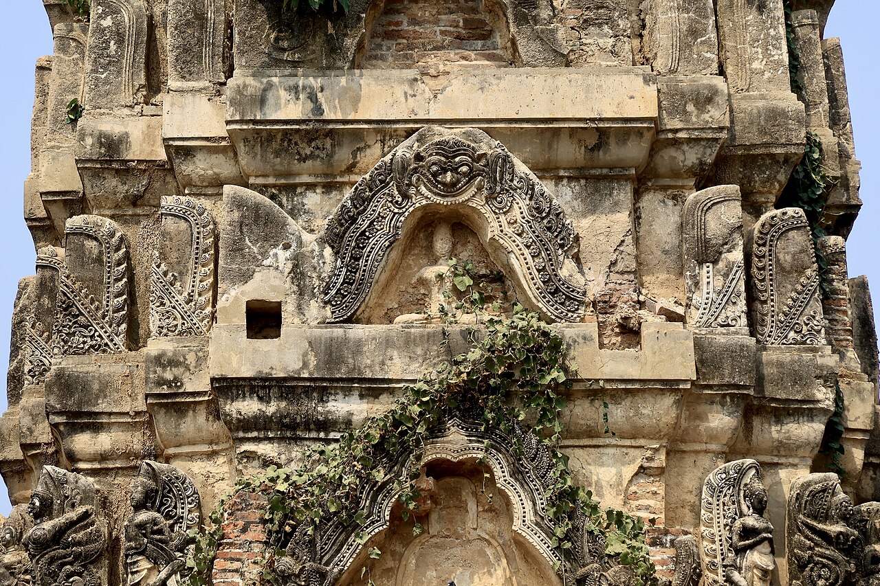 Phra Rahu (the eclipse-swallower) — Détail du prang recouvert de stuc  avec Kala (Rahu) au-dessus d'un bas-relief de Bouddha