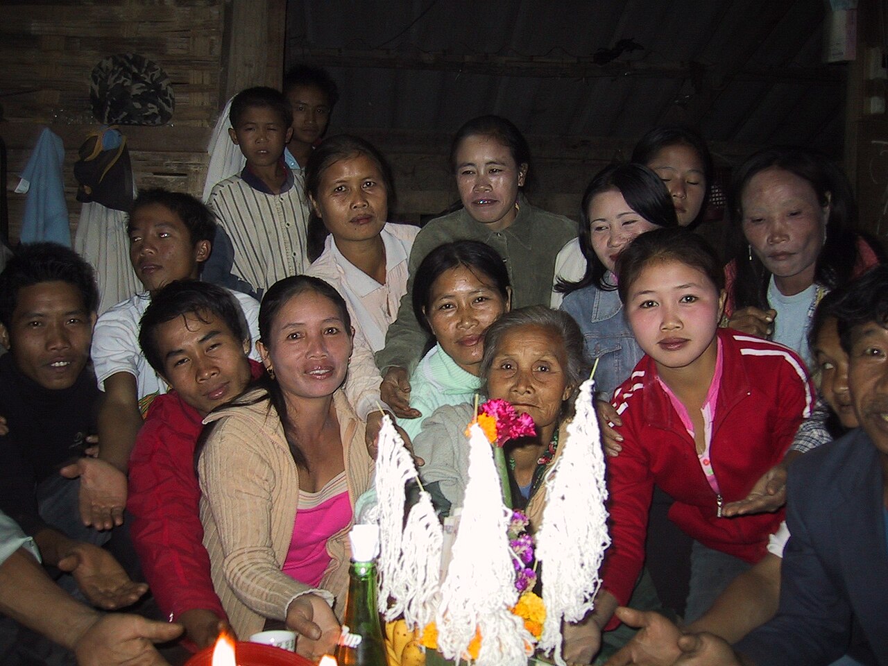 Sai sin (blessed cotton thread) — Group of people at a baci ceremony in a village near Luang Prabang