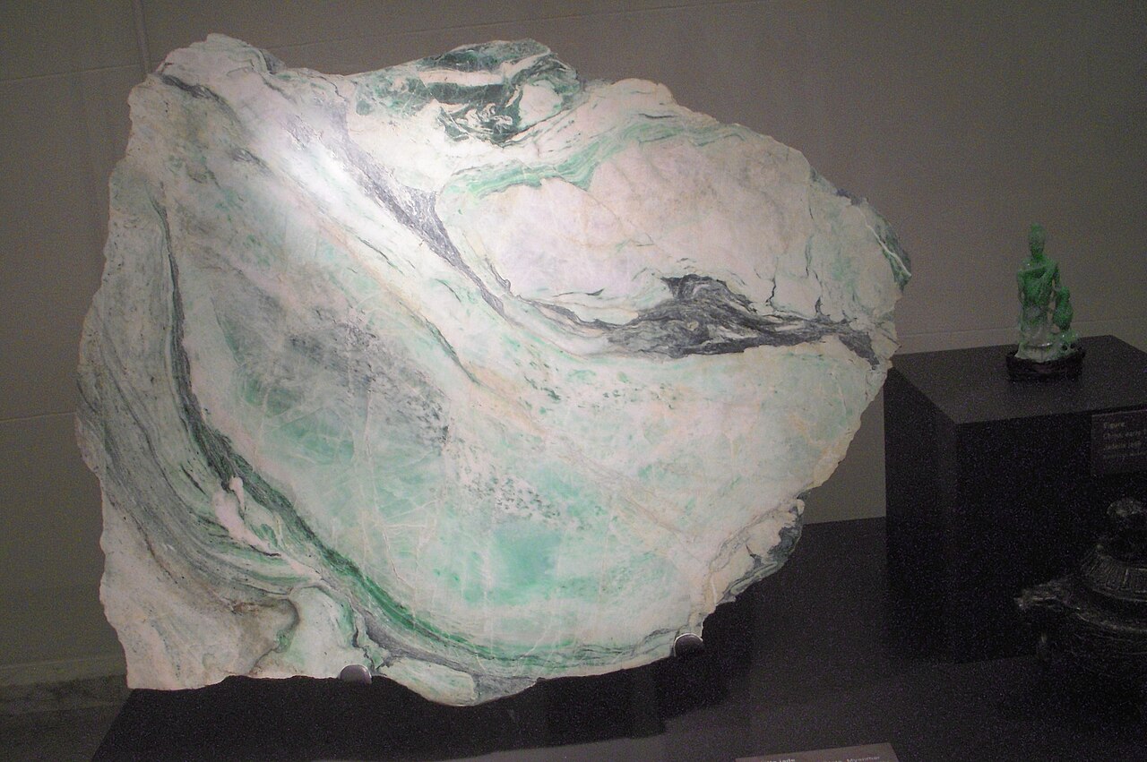 Burmese jadeite Buddha pendant — Unprocessed Jadeite rock with a finished Jade Buddha on its side, from China, on public display at Museum of Natural His