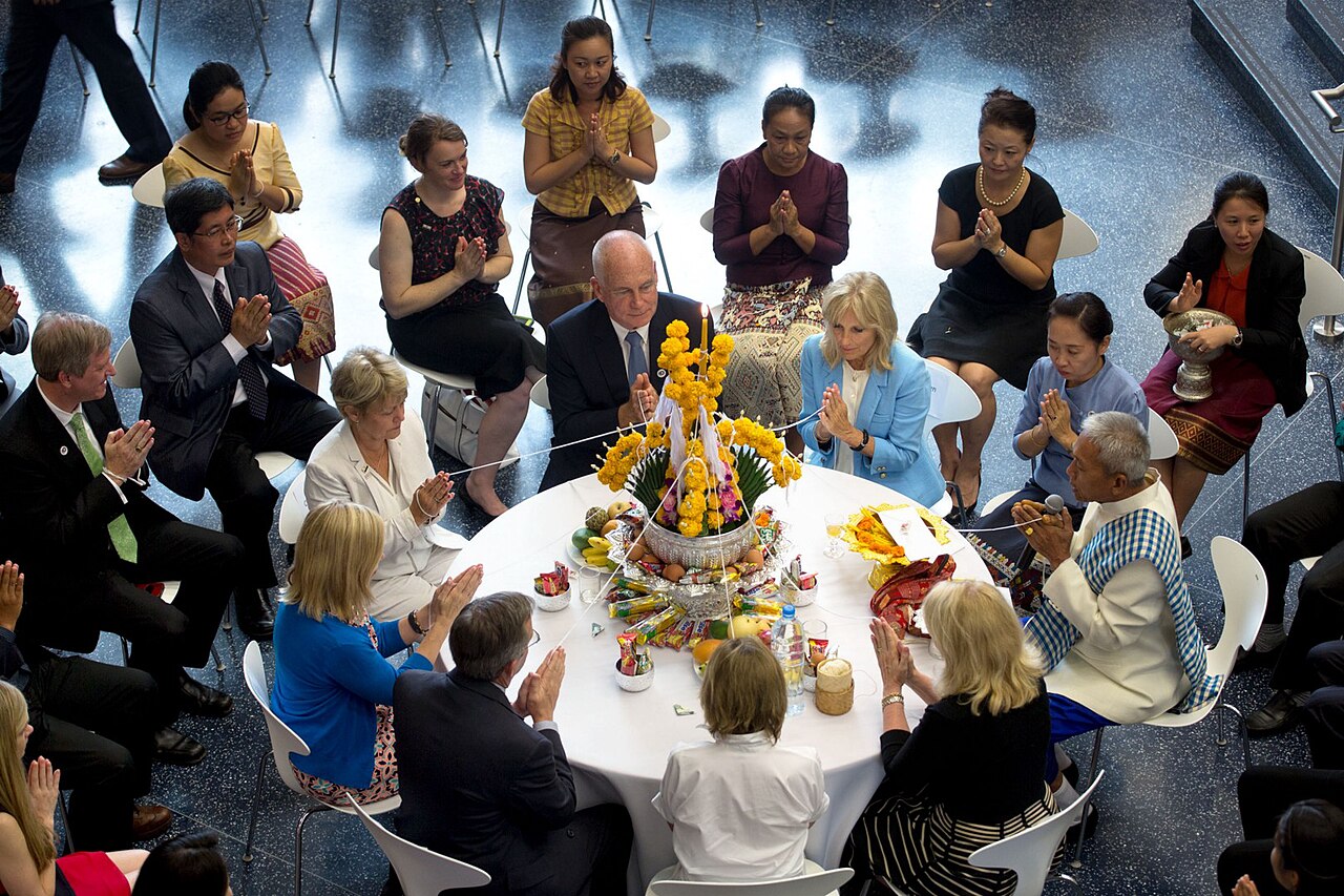 Sai sin (blessed cotton thread) — Dr. Jill Biden and U.S. Ambassador to Laos Daniel Clune take part in a Baci ceremony at the U.S. Embassy in Vientiane, L