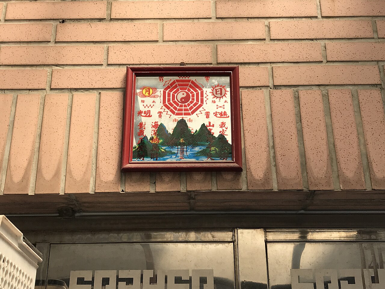 Bagua mirror — ​臺北市松山區國宅一樓住戶門楣，用以辟邪的八卦鏡。臺灣傳統的八卦鏡是正八角形，但因加工不易，近年也有如照所示，於方鏡印上八卦與道家符咒的簡易型。