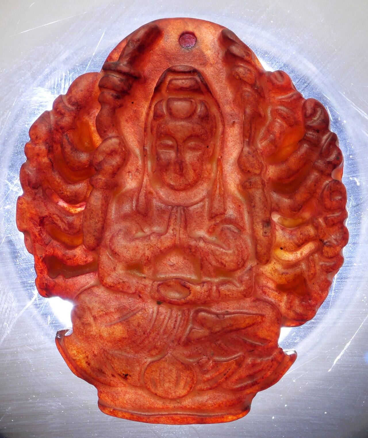 Guanyin pendant — Thousand-Armed Guanyin pendant, carved and dyed stone. 33mm width, 40mm length, 8mm tall